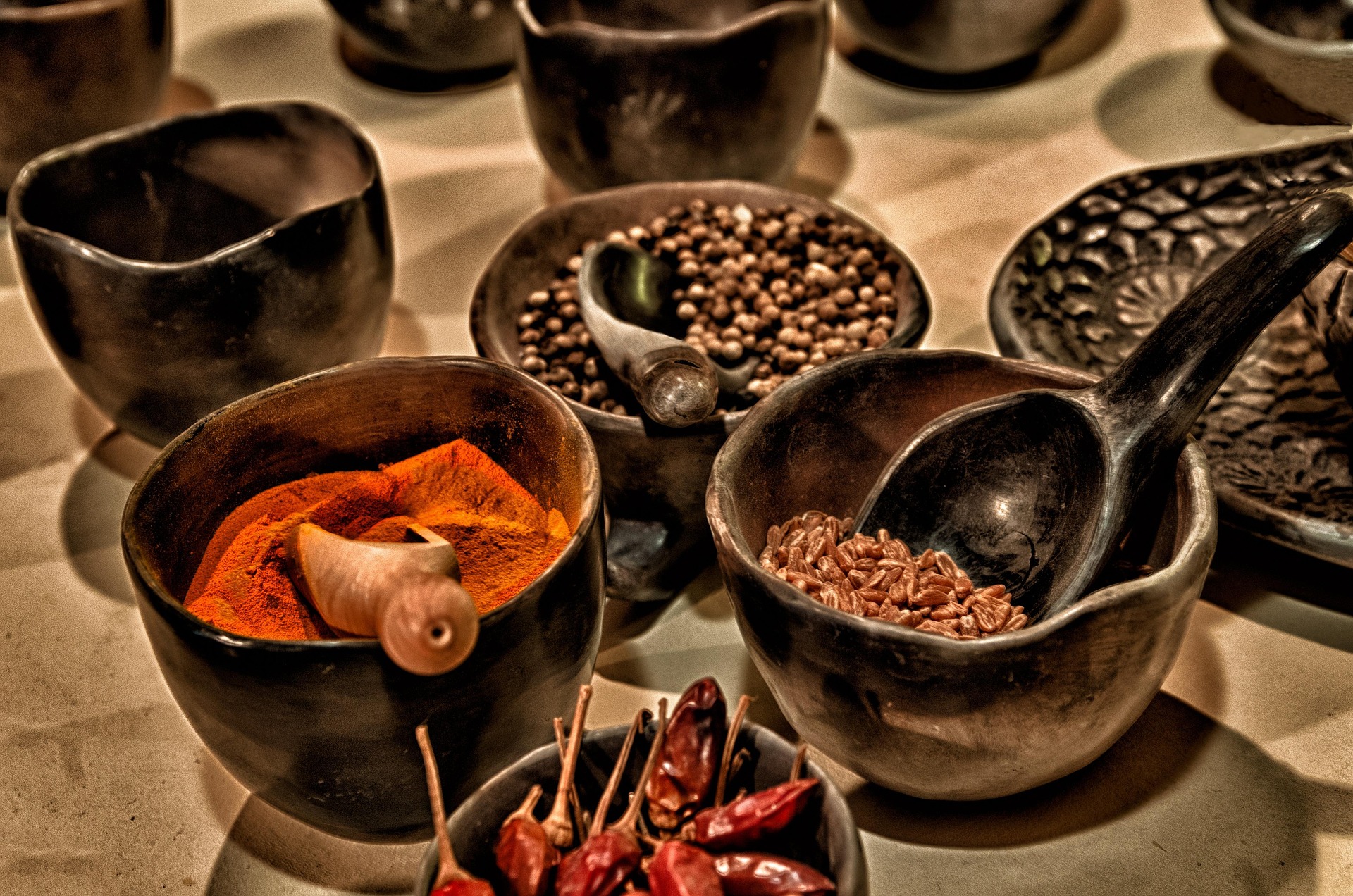 Mortiers et coupelles d'épices traditionnelles — curcuma, poivres, piments séchés